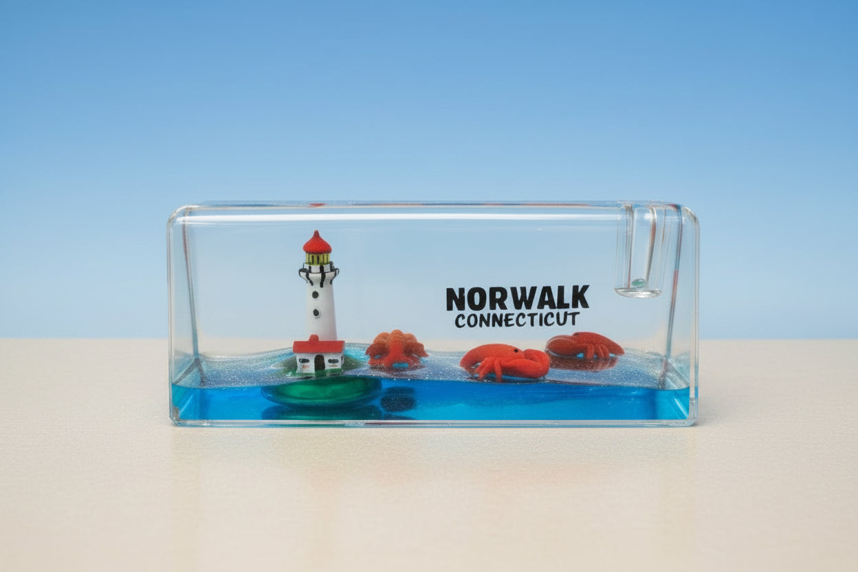 Plastic paperweight with a lighthouse, mini lobsters, and text 'Norwalk Connecticut'